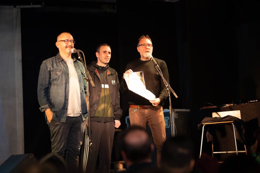ZeroCalcare, Valerio Mastandrea e Johnny Palomba sul palco durante l'asta del Tetraink